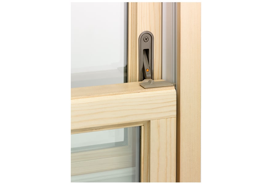 A double-hung window with a window opening control device that limits its opening to less than 4 inches.
