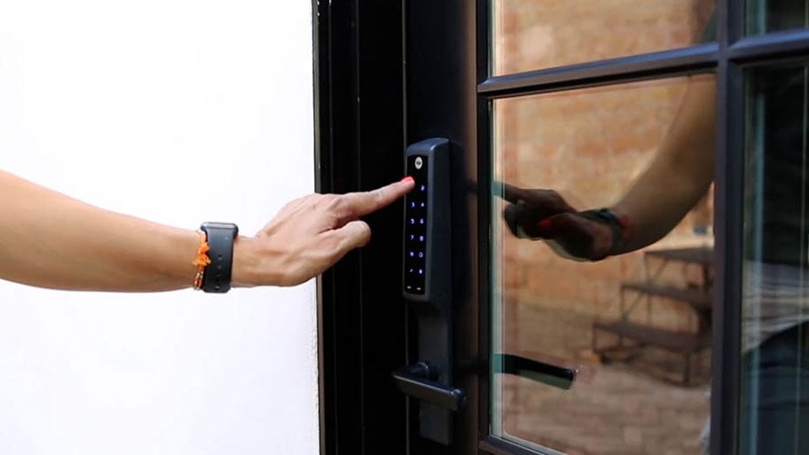 closeup image of woman unlocking the front door using keypad, Yale Lock
