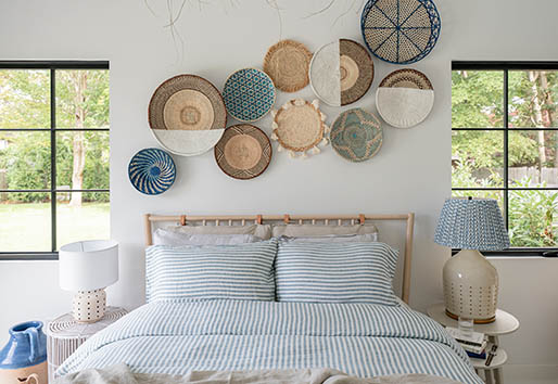 Bed with two windows over nightstands and Mediterranean-inspired decor