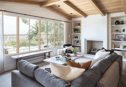 White oak windows in a living room frame a canyon view outside.