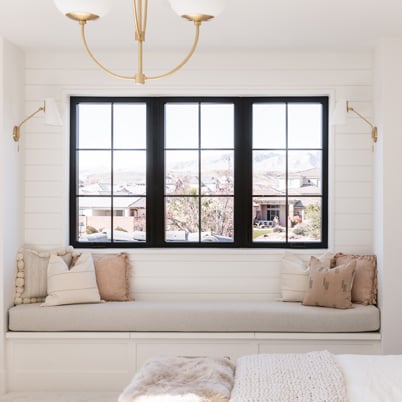 white window seat design with black framed andersen 100 series casement window