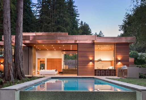 wood home in woods with pool showcasing andersen floor to ceiling windows