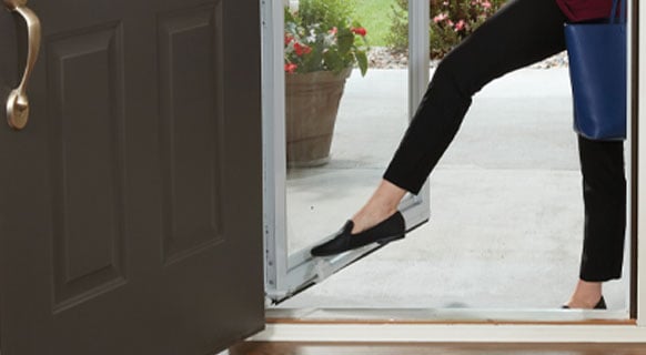 close up of woman in entry way using the standard close feature on andersen storm door