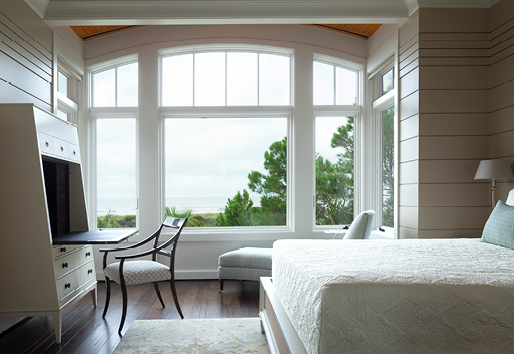 White bedroom with A-Series casement and picture windows with a water view