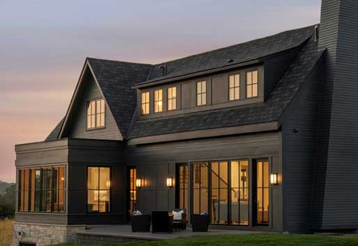 Exterior of black home with Andersen e-series and 400 series windows and hinged patio doors.