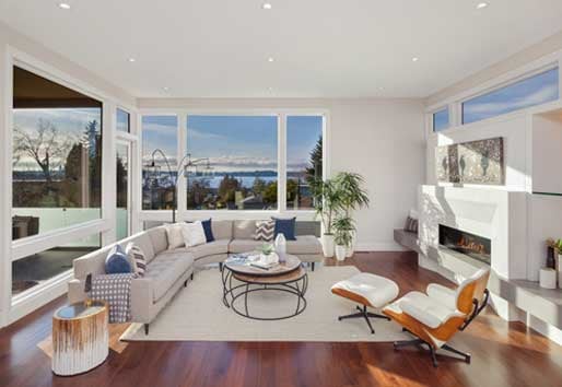 Interior view of white living room with natural lighting from Andersen floor-to-ceiling windows.