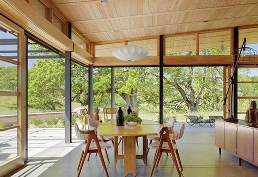 Open dining room with natural light coming inside from wood corner liftslide and pivot doors