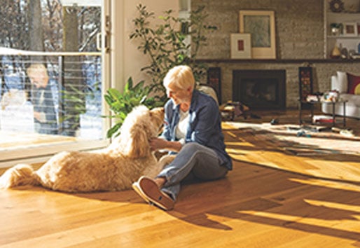 woman sitting on floor petting dog
