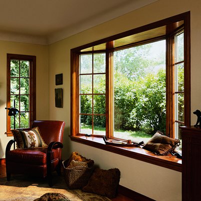 Living room with nature view outside through Andersen 400 Series Bay windows.