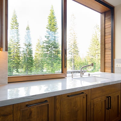 Andersen pass-through window over sink with view of pine trees